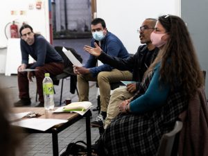 A group of artists sit talking.