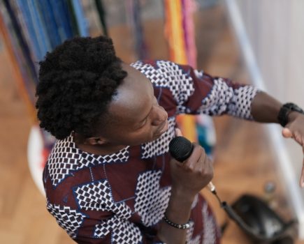 An artist talks into a microphone.